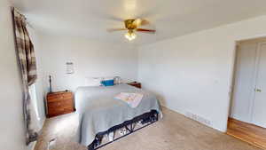 Carpeted bedroom featuring ceiling fan and baseboards