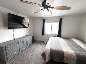 Bedroom with dark carpet and ceiling fan