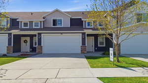 Traditional-style home with a shingled roof, concrete driveway, a porch, and a garage