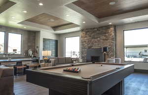 Playroom featuring a wooden tray ceiling, plenty of natural light, billiards, a stone fireplace, and recessed lighting