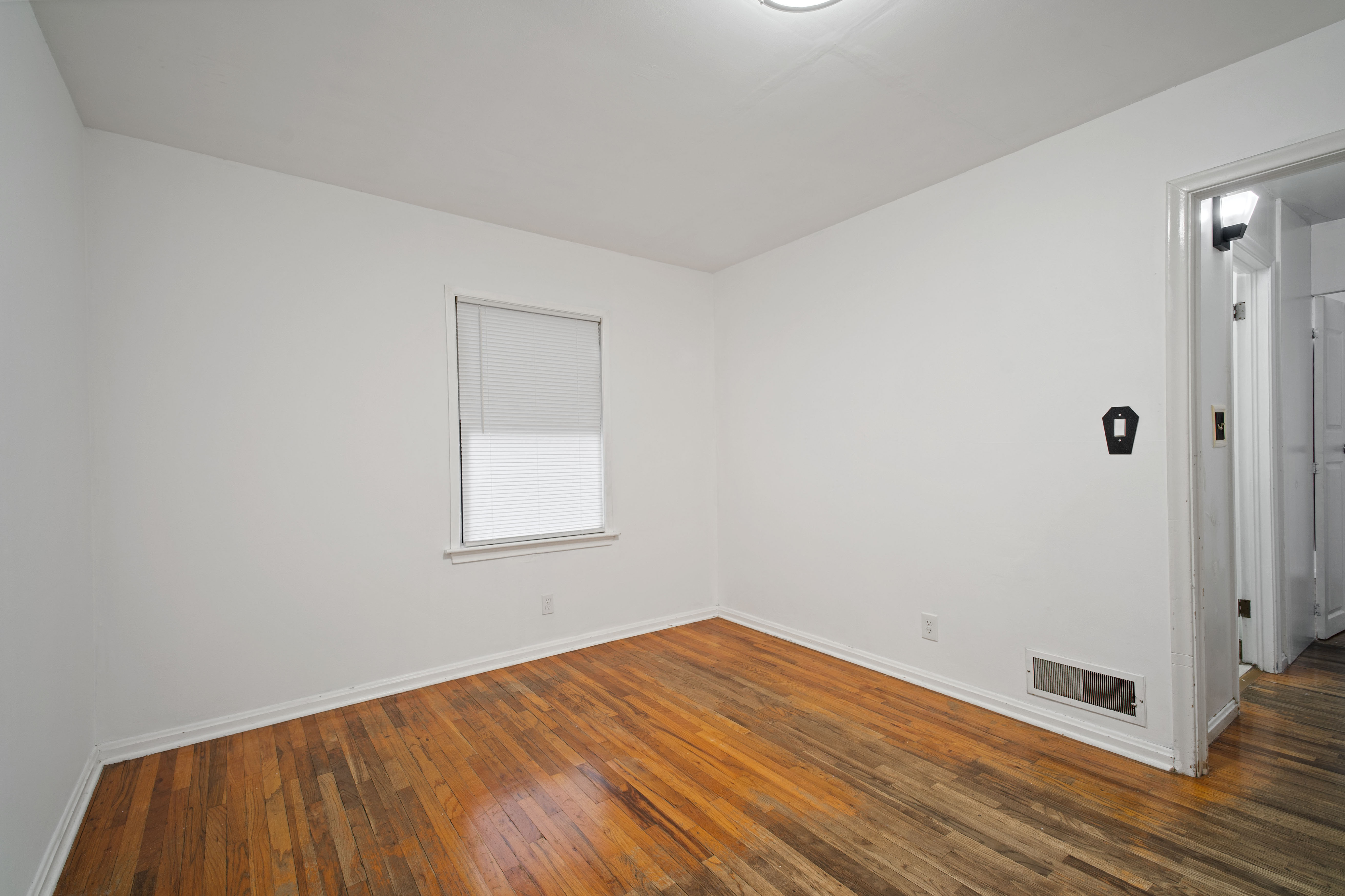 Empty room featuring dark wood-type flooring and baseboards