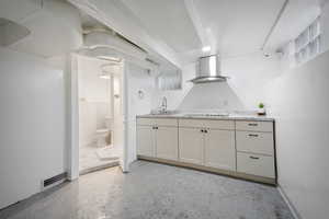 Kitchen with light counter tops and wall chimney exhaust hood