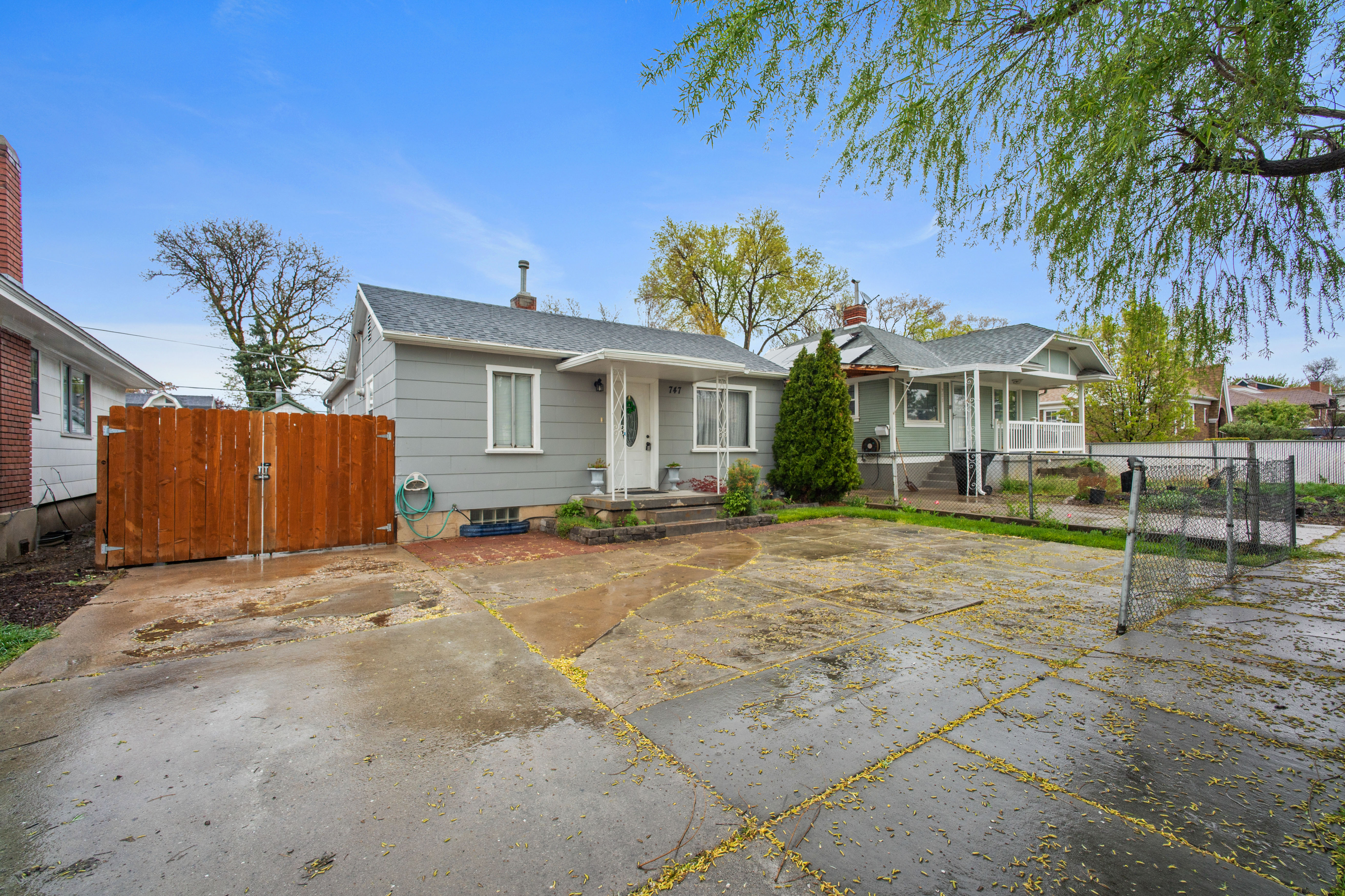 Bungalow-style house featuring a gate, a chimney, roof with shingles, and a patio