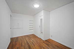 Empty room featuring dark wood-type flooring and built in features