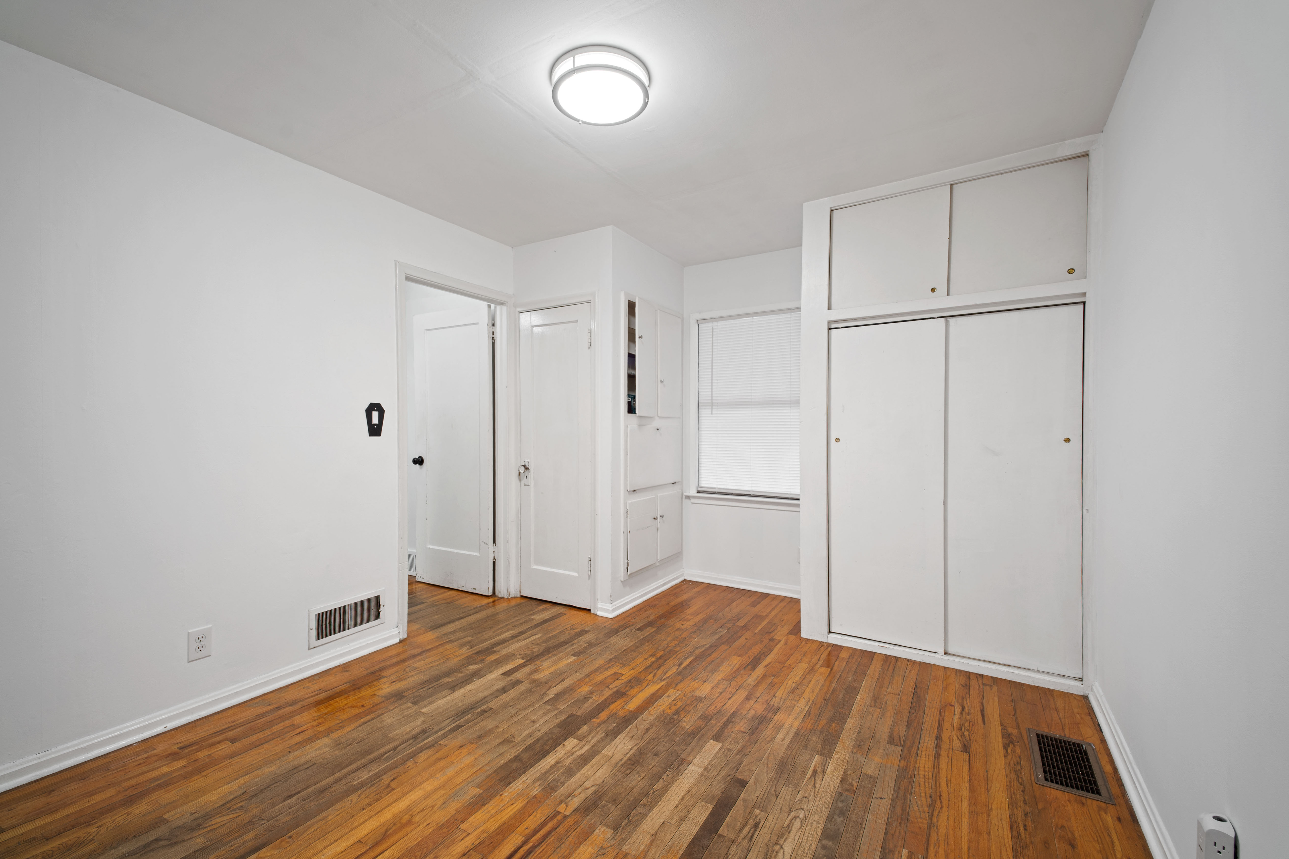 Unfurnished bedroom with dark wood-style floors and a closet