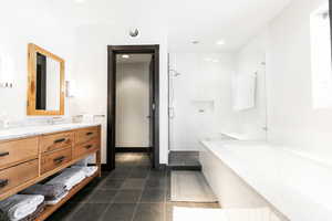 Full bathroom with vanity, a stall shower, a garden tub, dark tile patterned floors, and recessed lighting
