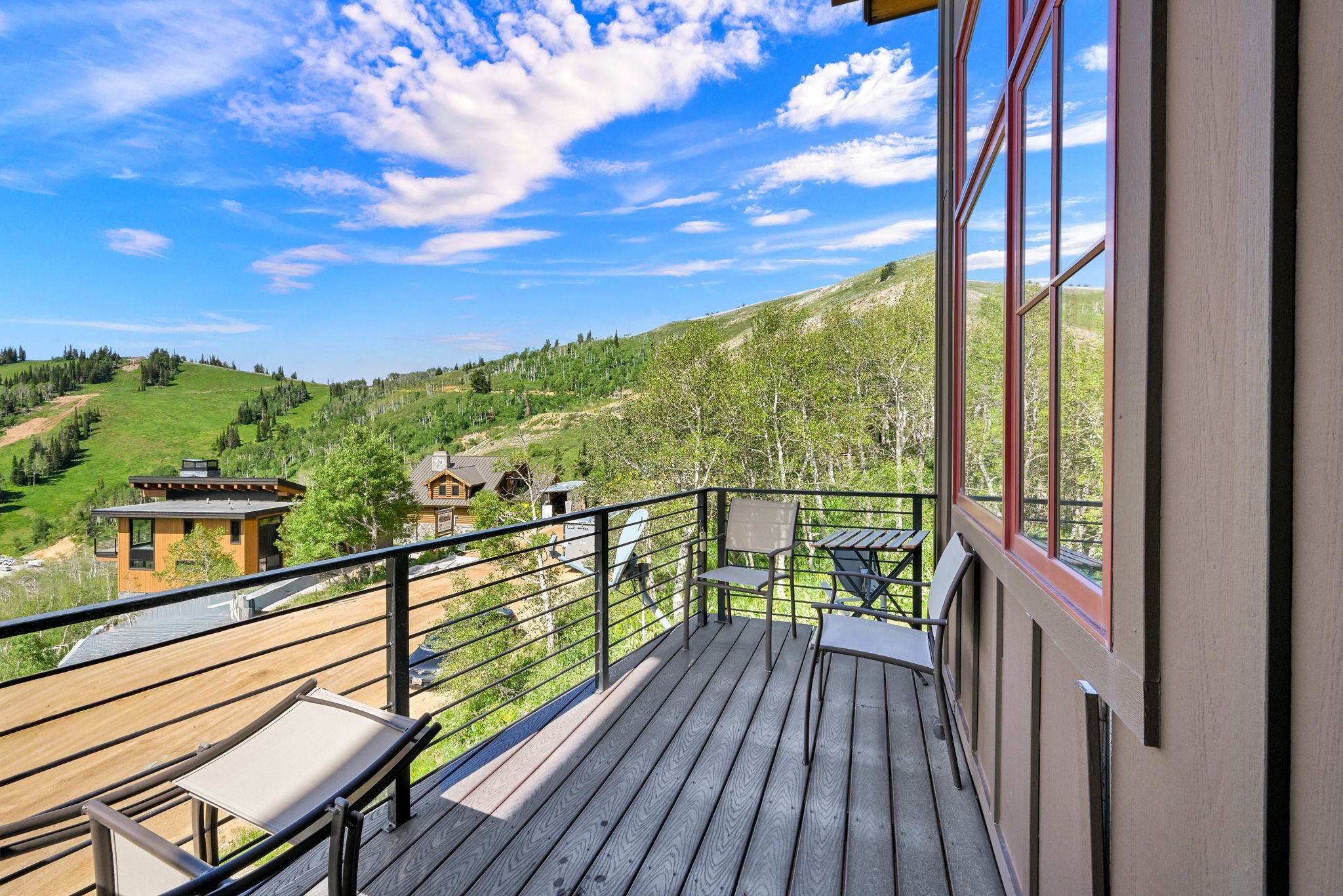 Expansive outdoor deck with wood-finish flooring and a black metal railing