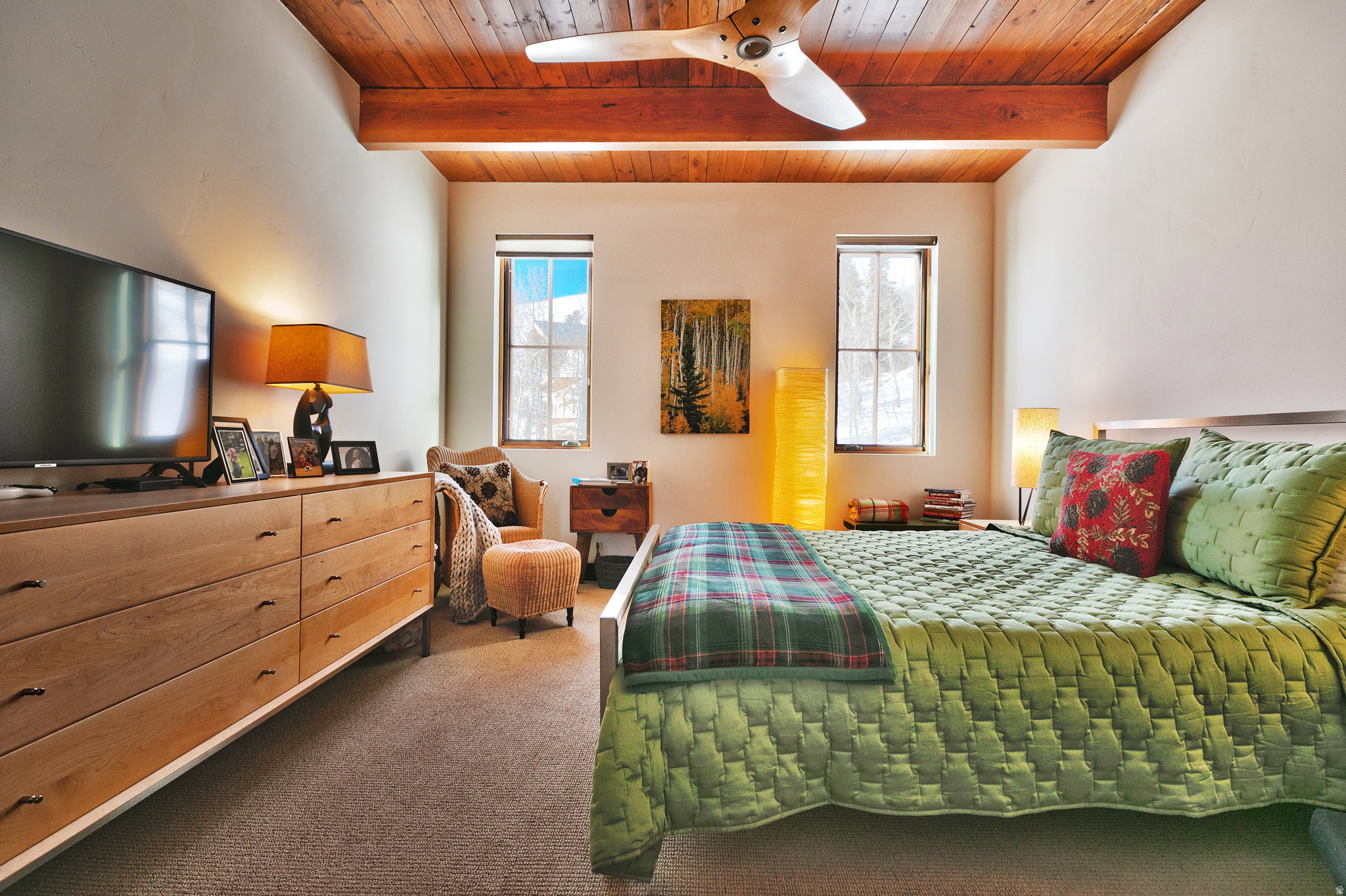 Bedroom featuring a wooden ceiling with exposed beams, dark colored carpet, and a ceiling fan