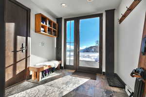 Mudroom with stone tile floors, a baseboard heating unit, and recessed lighting