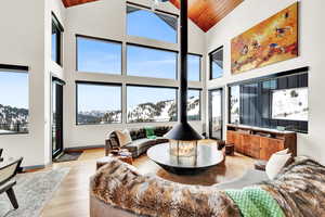 Living area featuring light wood-style floors, a vaulted wood ceiling, and healthy amount of natural light