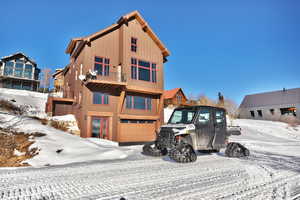 View of front of house featuring an attached garage and a balcony