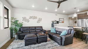Living room featuring ceiling fan, light wood finished floors, and recessed lighting