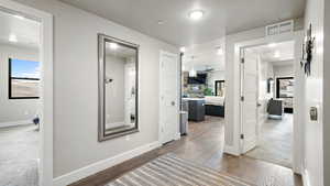Corridor with dark wood-style floors and healthy amount of natural light
