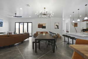 Dining area with a ceiling fan, finished concrete floors, and a chandelier