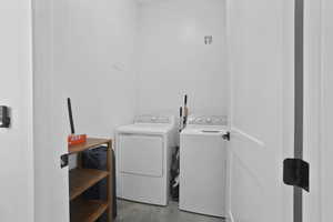 Laundry area with independent washer and dryer and concrete floors