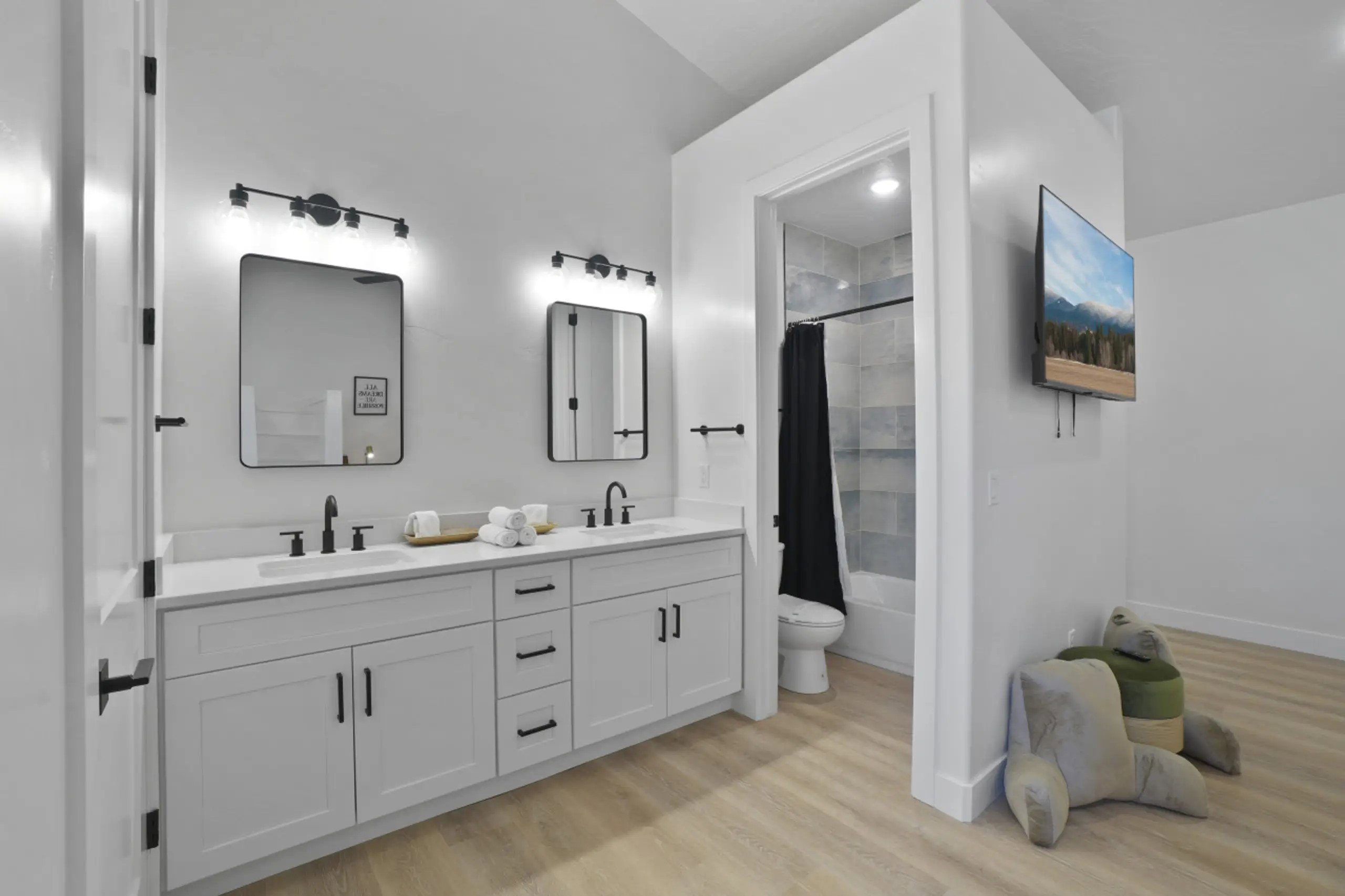 Bathroom featuring double vanity, light wood-style floors, and shower / bath combination with curtain