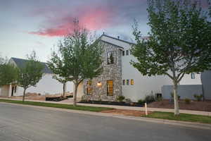 View of front facade featuring stone siding and stucco siding
