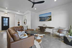 Living room featuring finished concrete floors, recessed lighting, and ceiling fan
