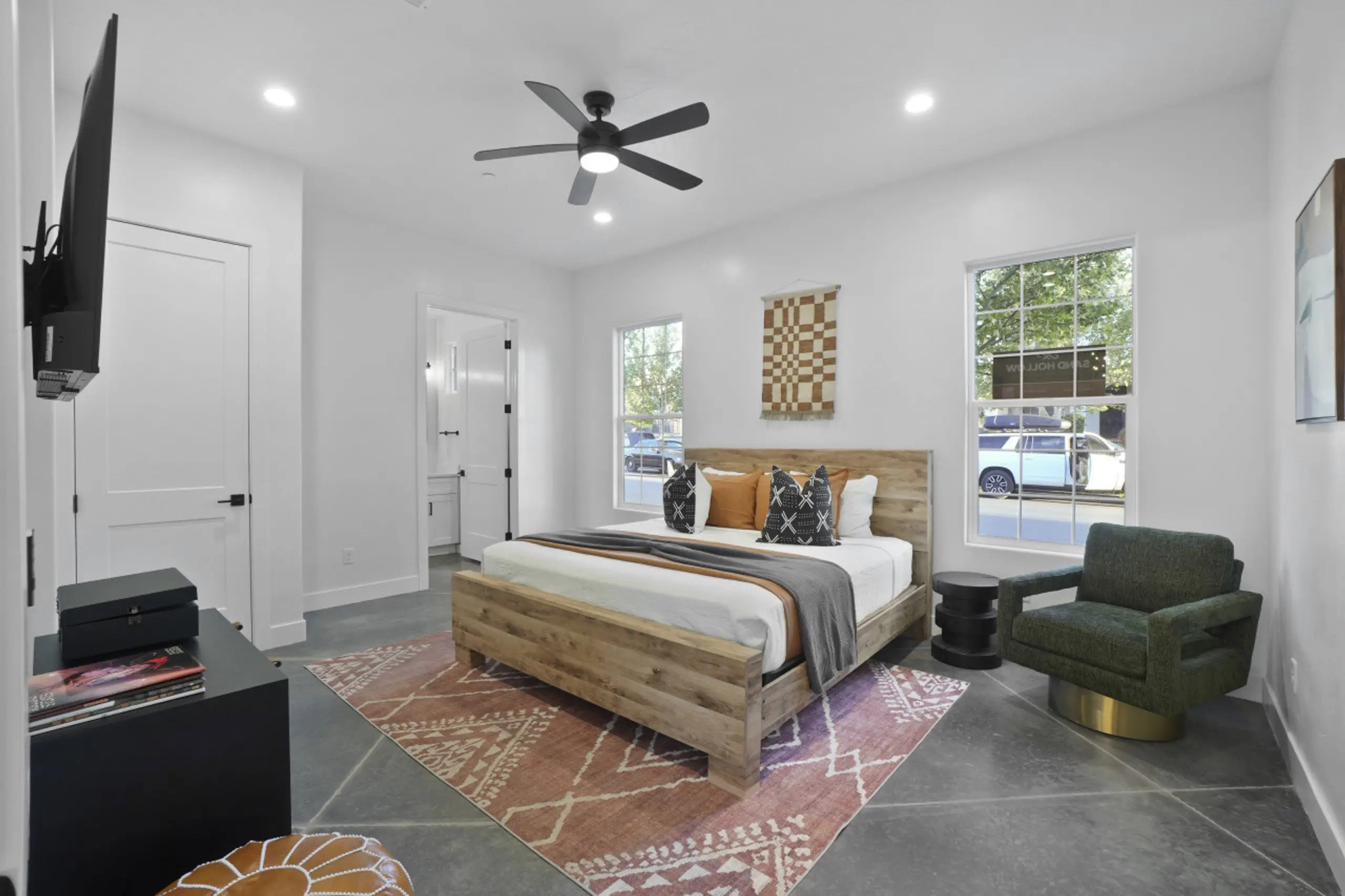 Bedroom featuring finished concrete flooring, a ceiling fan, recessed lighting, and connected bathroom