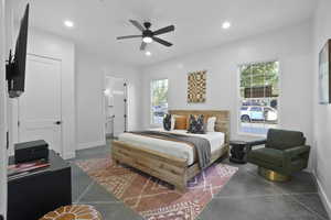 Bedroom featuring finished concrete flooring, a ceiling fan, recessed lighting, and connected bathroom