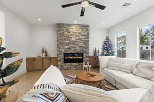 Living room featuring a ceiling fan, parquet floors, a fireplace, and recessed lighting