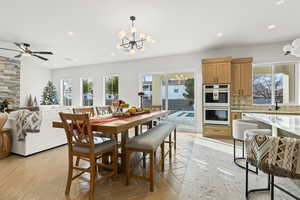 Dining area featuring a chandelier, a ceiling fan, and parquet flooring