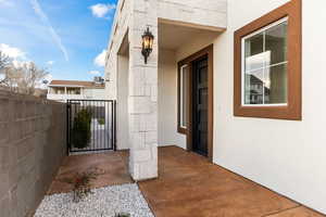 Doorway to property with a gate and stucco siding
