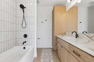 Bathroom with vanity, shower / washtub combination, and light tile patterned flooring