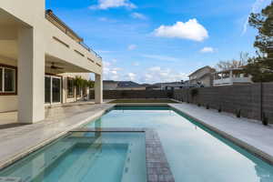 Integrated pool / spa featuring a patio area, a fenced backyard, and a residential view