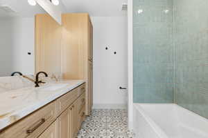 Bathroom featuring vanity, light tile patterned floors, and shower / bathtub combination