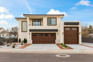 Contemporary home featuring stucco siding, driveway, and a garage