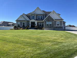 Craftsman-style home featuring stone siding and covered porch