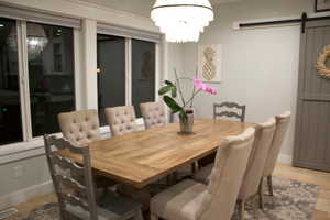Dining area featuring a barn door, hanging lights, and light wood finished floors
