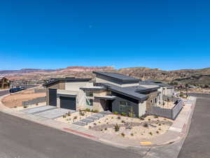 View of front of house featuring stone siding, a mountain view, stucco siding, driveway, and a garage