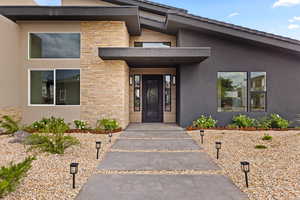 Property entrance featuring stone siding and stucco siding
