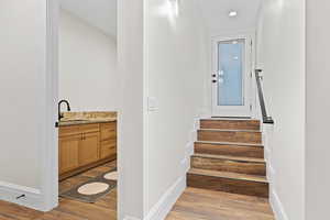 Staircase with wood finish floors and recessed lighting
