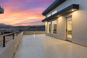 Patio terrace at dusk featuring a patio and a mountain view