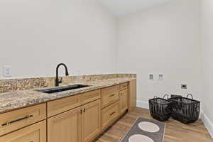 Laundry room with washer hookup, wood finish floors, electric dryer hookup, and cabinet space