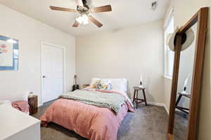 Bedroom with large walk-in closet and a ceiling fan