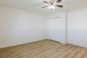 Unfurnished bedroom with light wood finished floors, a closet, and ceiling fan