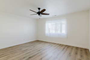 Empty room with light wood-style floors and ceiling fan