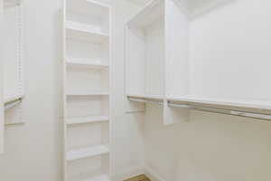 Walk in closet with light wood-style flooring