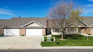 Single story home featuring brick siding, a front lawn, concrete driveway, a garage, and roof with shingles