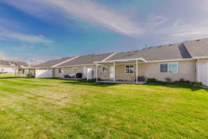 Back of house featuring a patio area, stucco siding, and a shingled roof