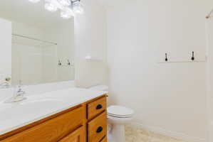 Bathroom featuring vanity, light tile patterned flooring, and a shower