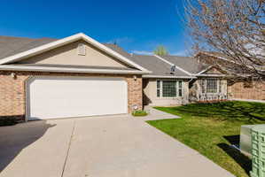 Home with roof with shingles, concrete driveway, a front lawn, an attached garage, and brick siding