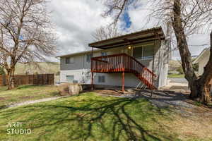 Rear view of property featuring a wooden deck and stairs