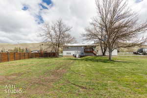 Fenced yard featuring stairs and a deck with mountain view