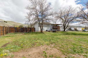 Fenced backyard featuring stairs and a deck with mountain view