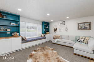 Living room with built in features, carpet flooring, recessed lighting, and a textured ceiling